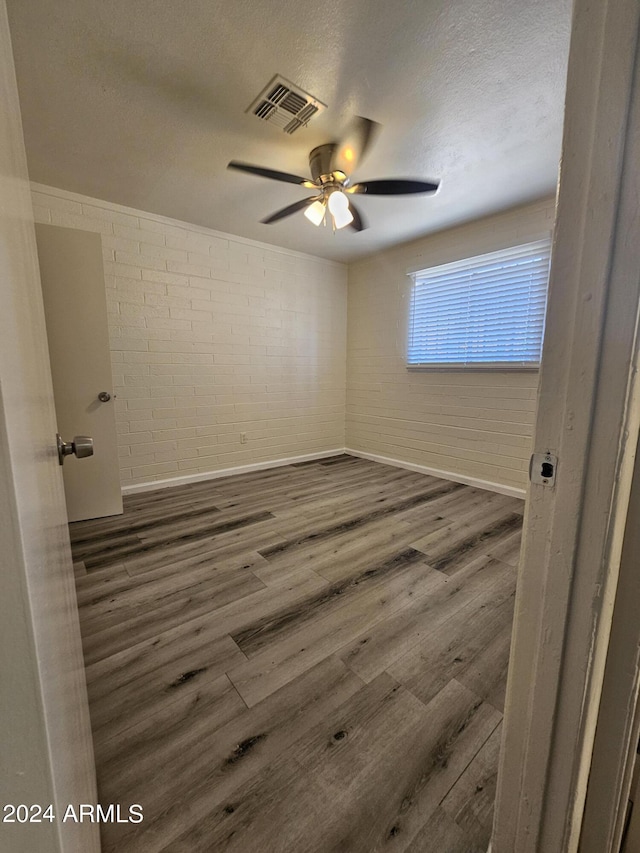 spare room featuring ceiling fan, dark hardwood / wood-style flooring, and a textured ceiling