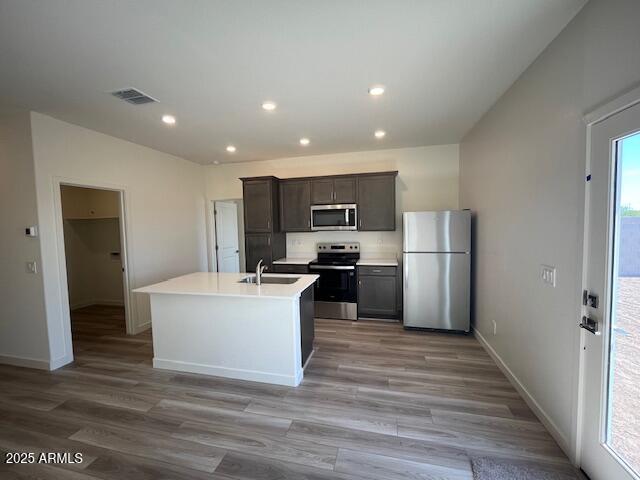 640 S Maricopa Rd, Florence, AZ 85132 - kitchen featuring appliances with stainless steel finishes, a sink, light wood-style flooring, baseboards, and a center island with sink