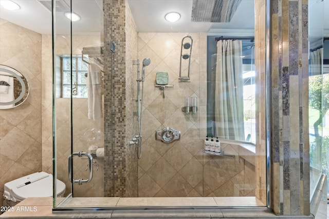 bathroom with an enclosed shower, plenty of natural light, and toilet