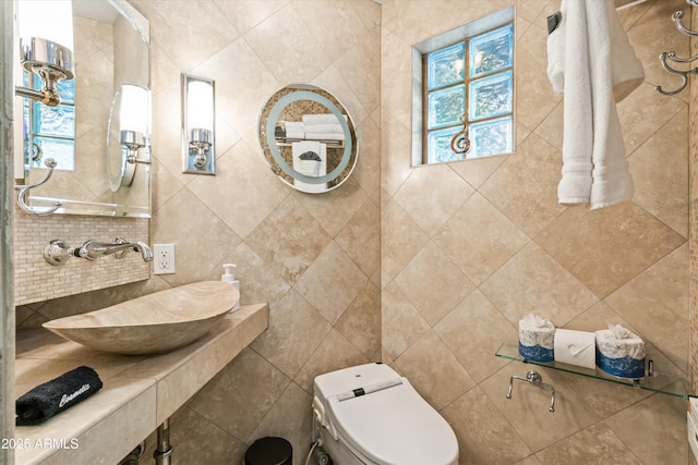 bathroom with toilet, sink, and decorative backsplash