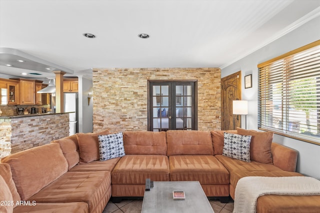 living room with decorative columns, light tile patterned floors, and french doors