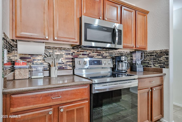 4318 W Apollo Rd, Laveen, AZ 85339 - kitchen with stainless steel appliances, tasteful backsplash, tile patterned floors, and brown cabinets