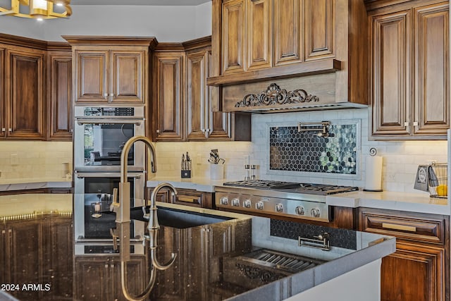 kitchen with stainless steel appliances, tasteful backsplash, and dark stone counters