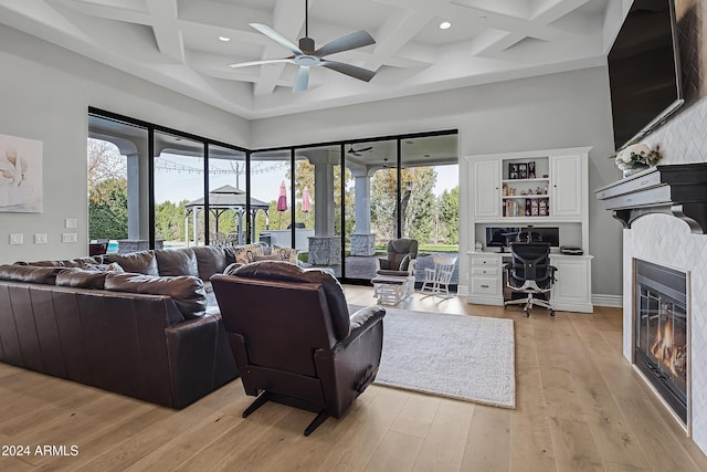 living room with beam ceiling, light hardwood / wood-style floors, ceiling fan, and coffered ceiling