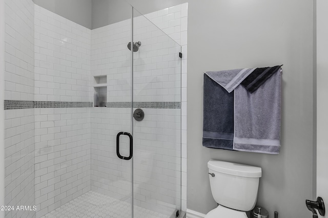 bathroom with an enclosed shower and toilet