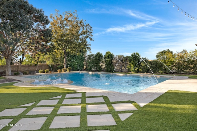 view of swimming pool with pool water feature, a patio area, and a yard