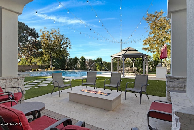 view of patio featuring pool water feature, a fire pit, and a gazebo