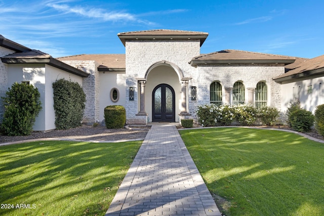 view of front of home featuring a front yard and french doors