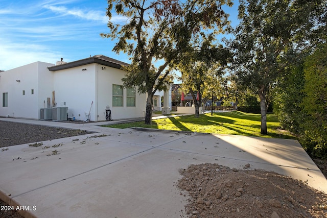 view of side of property with a lawn and central AC unit