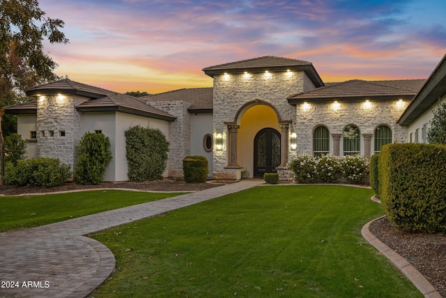 view of front of house featuring a yard and french doors