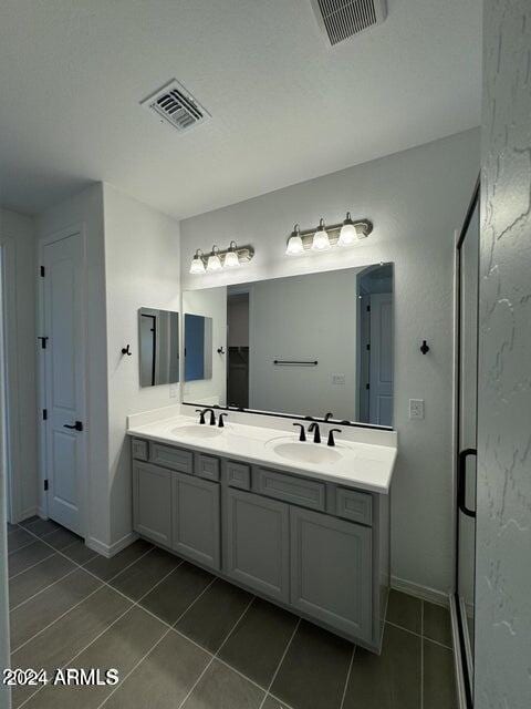 bathroom featuring tile patterned flooring, vanity, and walk in shower