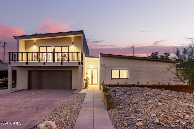 view of front of home with a garage and a balcony