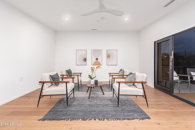 living area with ceiling fan and light hardwood / wood-style floors