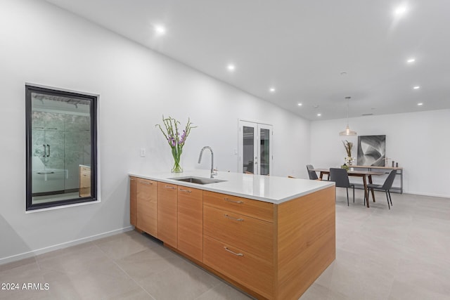 kitchen with pendant lighting, sink, kitchen peninsula, light tile patterned flooring, and french doors