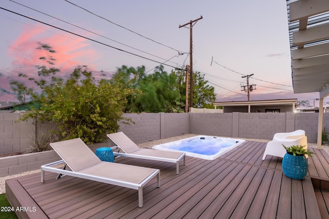 deck at dusk with an outdoor hot tub