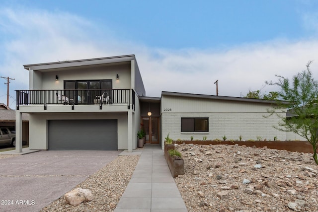 view of front facade with a garage and a balcony