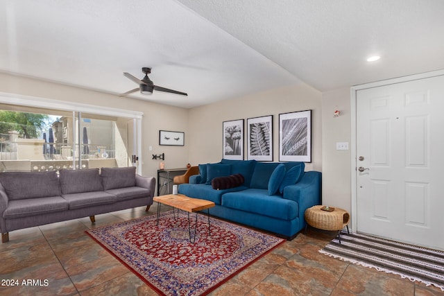 living room with a textured ceiling and ceiling fan