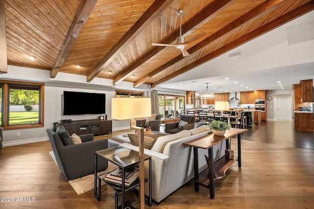 living room featuring dark hardwood / wood-style floors, lofted ceiling with beams, wooden ceiling, and ceiling fan with notable chandelier