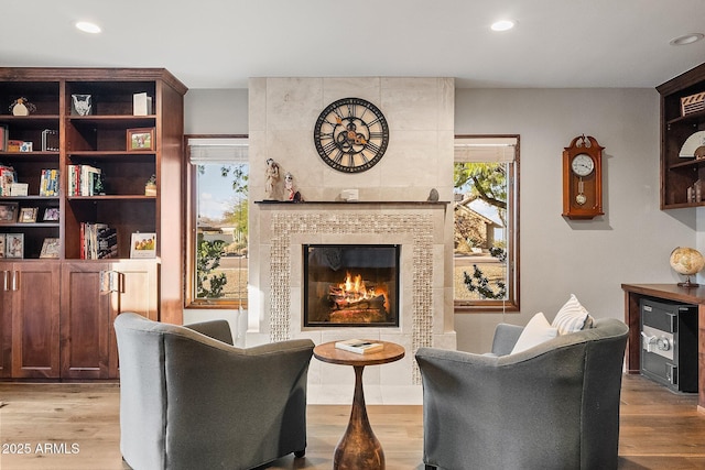 living room with light hardwood / wood-style flooring and a tiled fireplace