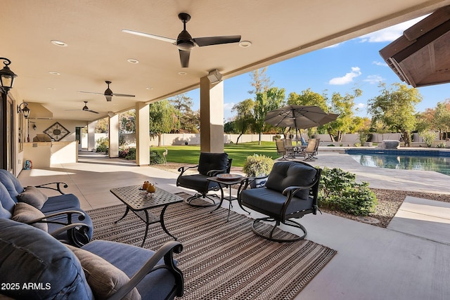 view of patio featuring a fenced in pool, ceiling fan, and an outdoor living space