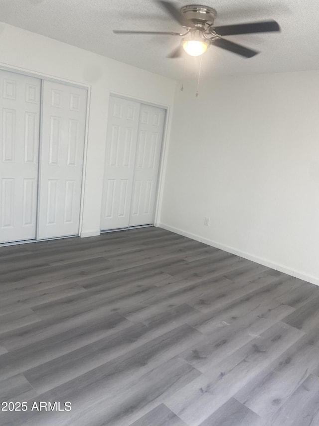 1452 E Emerald Ave, Mesa, AZ 85204 - unfurnished bedroom with dark wood-style flooring, a textured ceiling, baseboards, and a ceiling fan