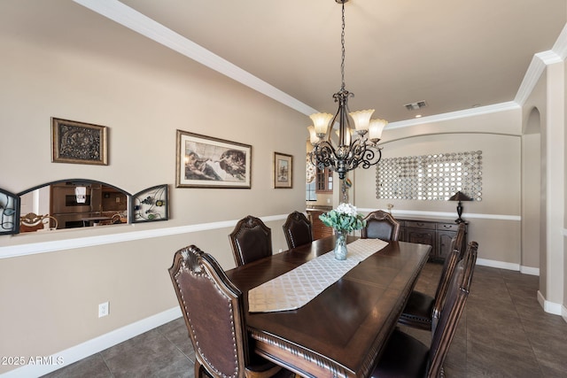 dining space featuring ornamental molding, dark tile patterned flooring, and a chandelier