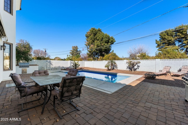 view of pool featuring an outdoor kitchen, an outdoor fire pit, and a patio