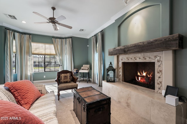 living room with crown molding, light colored carpet, a premium fireplace, and ceiling fan