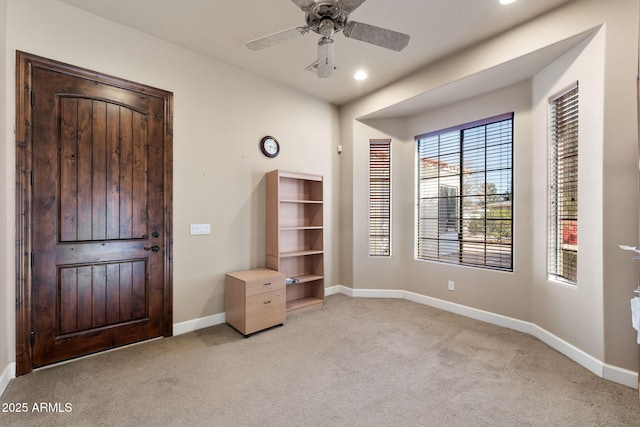 interior space featuring light colored carpet and ceiling fan