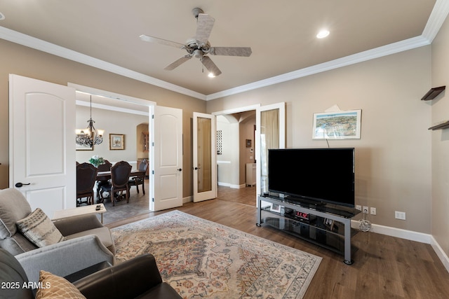 living room featuring crown molding, ceiling fan with notable chandelier, and hardwood / wood-style floors