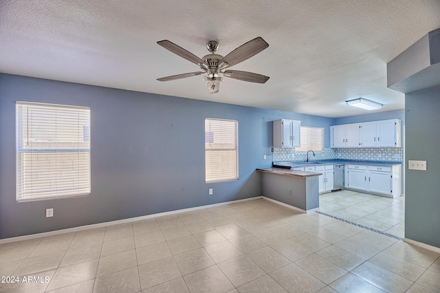 kitchen with white cabinets, ceiling fan, plenty of natural light, and tasteful backsplash