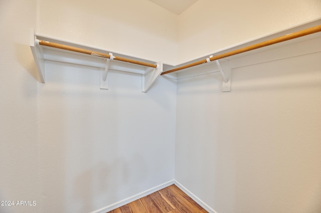 walk in closet with hardwood / wood-style flooring