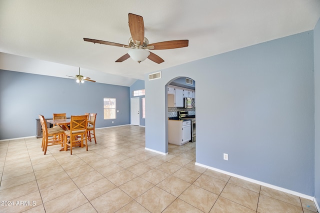 dining area with vaulted ceiling, ceiling fan, and light tile patterned floors