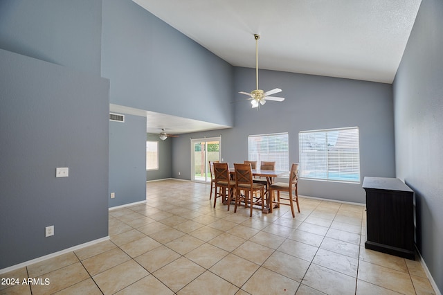 tiled dining room featuring ceiling fan and high vaulted ceiling