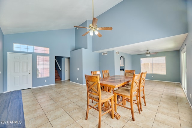 tiled dining room with high vaulted ceiling, a wealth of natural light, and ceiling fan