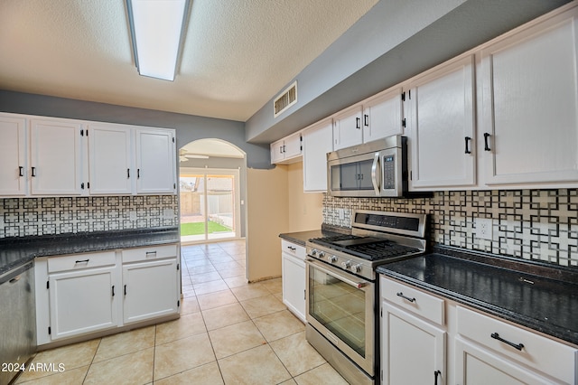 kitchen with stainless steel appliances, white cabinetry, and backsplash