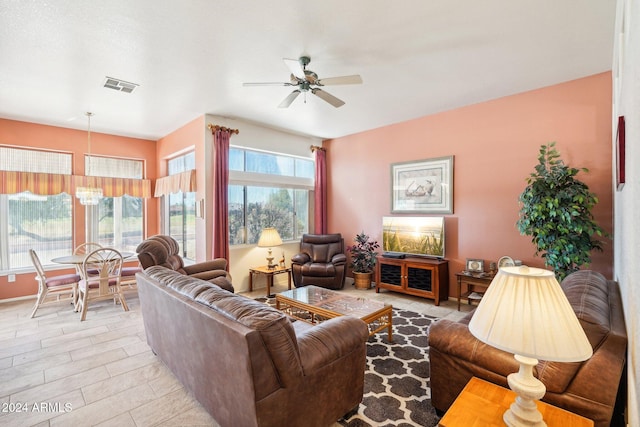 living room with visible vents and ceiling fan with notable chandelier