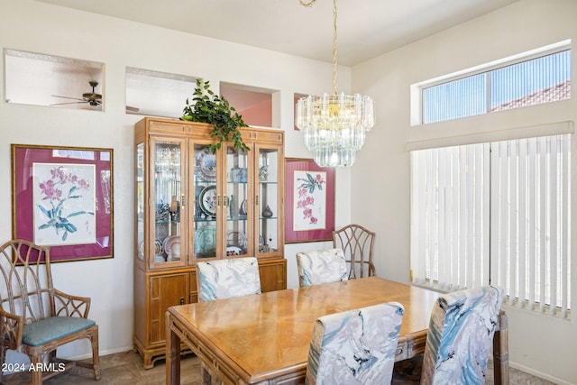 dining area with a healthy amount of sunlight, baseboards, and ceiling fan with notable chandelier