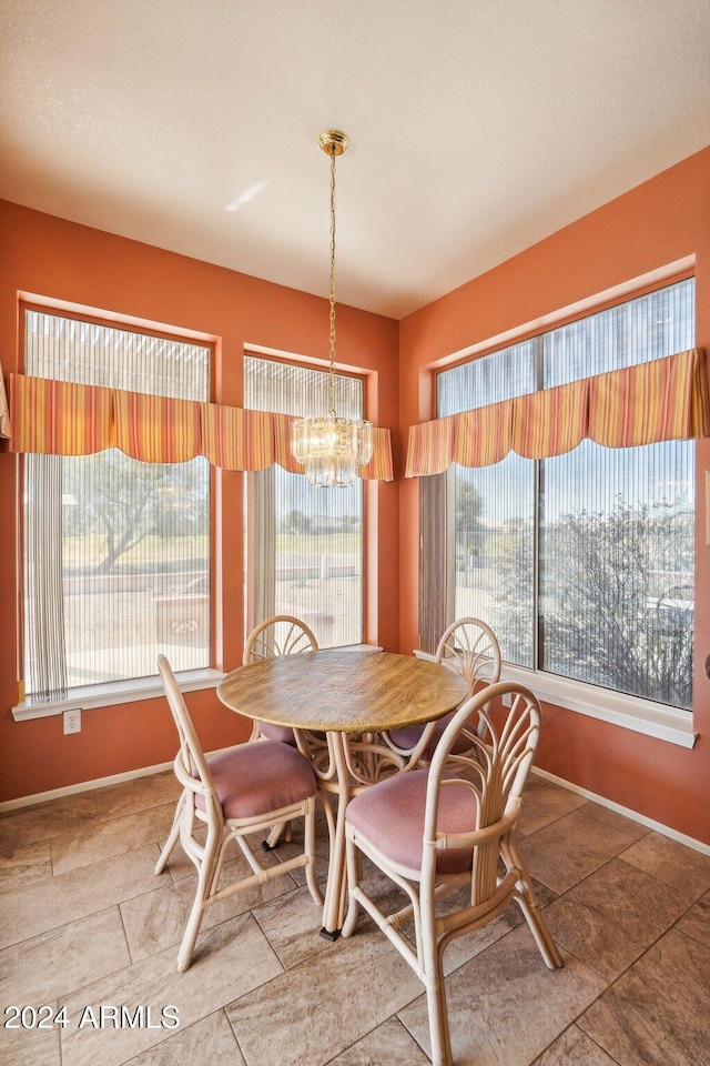 dining space featuring a chandelier, plenty of natural light, and baseboards