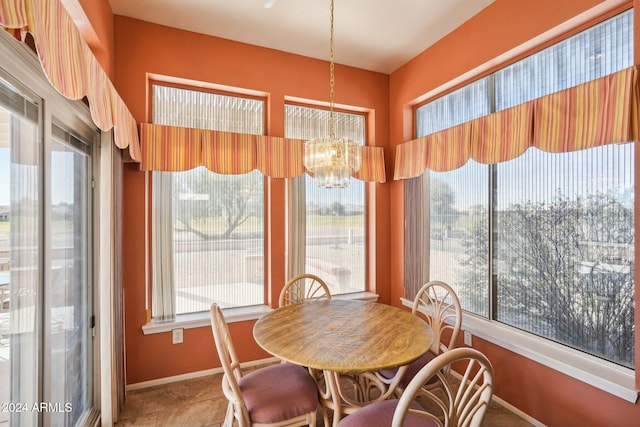 dining space with a chandelier, a healthy amount of sunlight, and baseboards