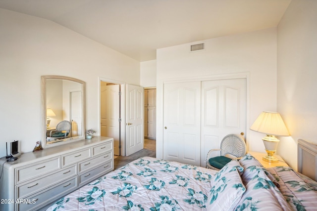 bedroom with lofted ceiling, visible vents, and a closet