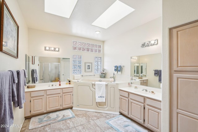 full bathroom featuring a skylight, a stall shower, tile patterned floors, a garden tub, and a sink