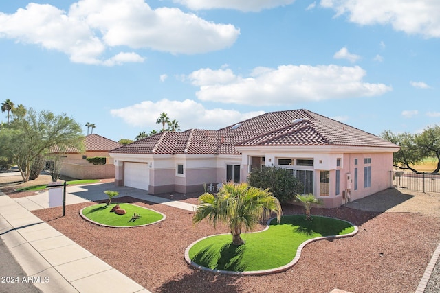 view of front of house featuring driveway, a tiled roof, fence, and stucco siding