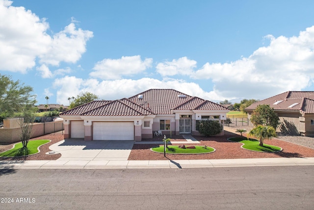 mediterranean / spanish-style home featuring a garage, a tile roof, fence, and stucco siding