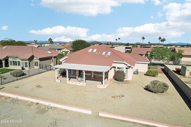 view of front of property featuring fence private yard, a tile roof, a residential view, and a patio