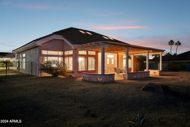 back of house featuring a yard, a patio area, and stucco siding