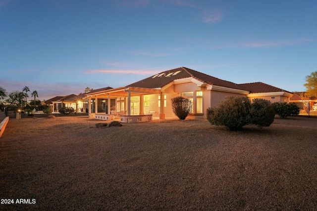 view of front of property with a tile roof, fence, and stucco siding