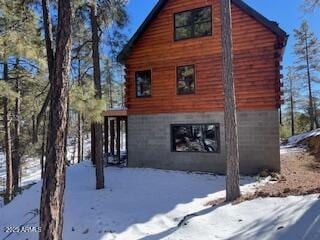 view of snowy exterior with log exterior