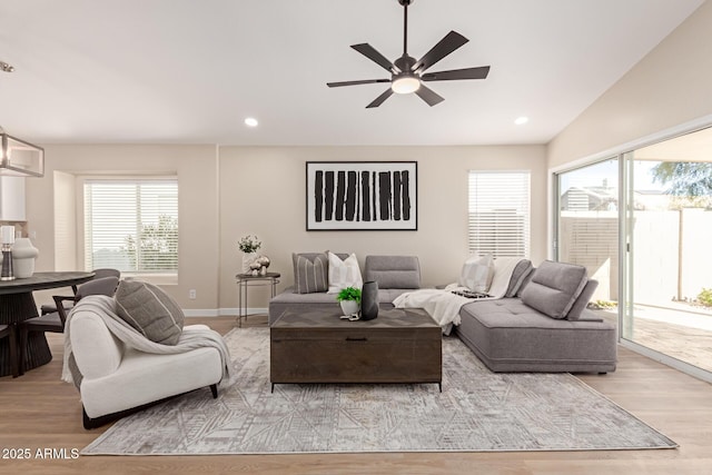 living room with ceiling fan, lofted ceiling, and light hardwood / wood-style flooring