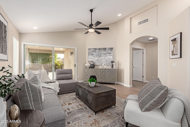 living room with vaulted ceiling, ceiling fan, and light hardwood / wood-style flooring